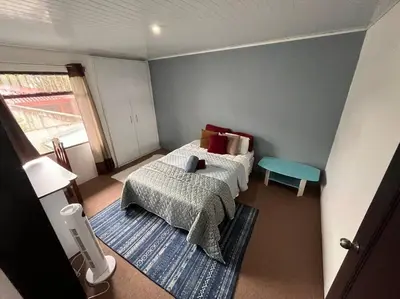 a small bedroom with a bed and a table at Beautiful house in The center of San Ramón in San Ramón