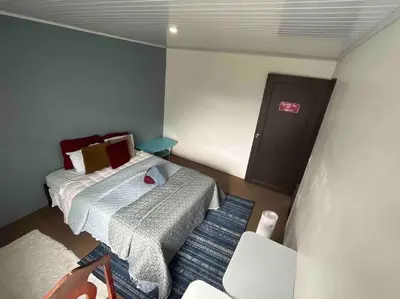 a small bedroom with a bed and a chair at Beautiful house in The center of San Ramón in San Ramón