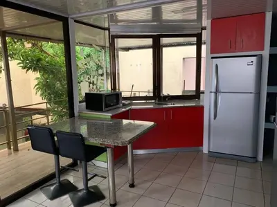 a kitchen with a table and a white refrigerator at Beautiful house in The center of San Ramón in San Ramón