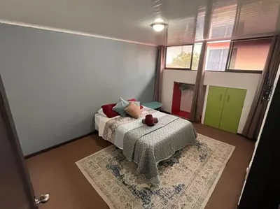 a bedroom with a bed with a teddy bear on it at Beautiful house in The center of San Ramón in San Ramón
