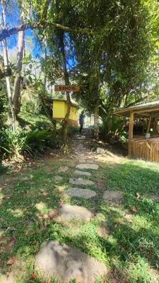 a path in a yard with a person walking down it at Hospedajes Richie Eco Camp in Providencia