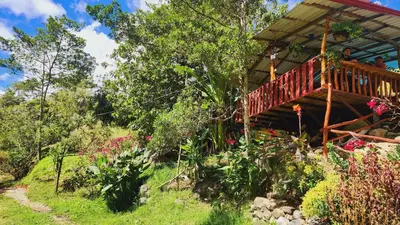 a house with a wooden deck in a garden at Hospedajes Richie Eco Camp in Providencia