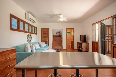 a living room with a blue couch and a table at Casa Palma Real in Playa Junquillal