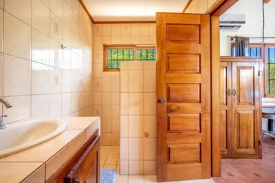 a bathroom with a sink and a shower and a door at Casa Palma Real in Playa Junquillal