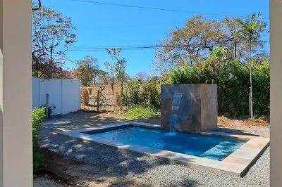 a swimming pool in the driveway of a house at Casa Palma Real in Playa Junquillal