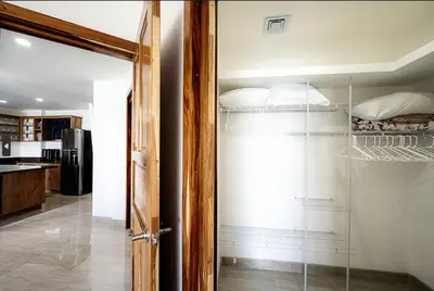 a glass door leading into a room with a bedroom at Lake Arenal Condos in Naranjos Agrios