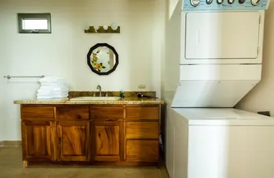 a bathroom with a sink and a white refrigerator at Lake Arenal Condos in Naranjos Agrios