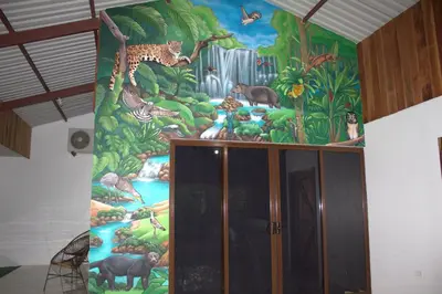 a mural of animals on a wall in a room at Home La Fortuna in Fortuna
