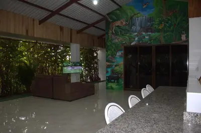 a room with white chairs and a wall with a painting at Home La Fortuna in Fortuna