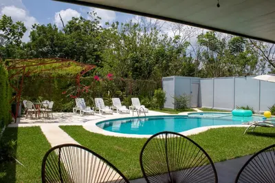 a swimming pool with chairs and a table at Home La Fortuna in Fortuna
