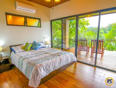 a bedroom with a bed and a balcony at Modern Mountain View Home by Nauyaca Waterfall in Platanillo