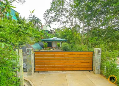 a wooden fence with a house in the background at Modern Mountain View Home by Nauyaca Waterfall in Platanillo