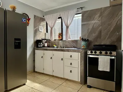 a kitchen with a stainless steel refrigerator and a stove at Brisa Amatista - Casa completa y centrica en San Ramón #1 in Palmitos Sur