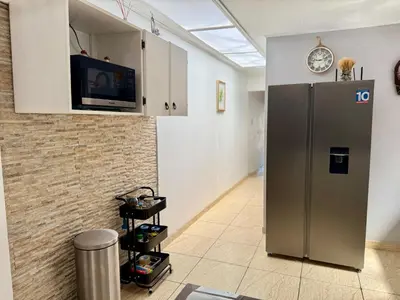 a kitchen with a refrigerator and a tv on a wall at Brisa Amatista - Casa completa y centrica en San Ramón #1 in Palmitos Sur