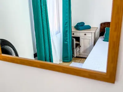 a mirror reflecting a bedroom with green curtains and a bed at Brisa Amatista - Casa completa y centrica en San Ramón #1 in Palmitos Sur