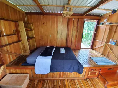 a bed in the inside of a wooden boat at Digrú Spaa in Pejibaye