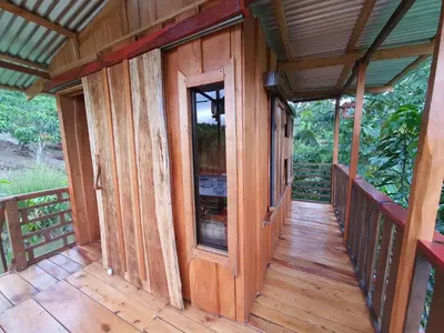 a wooden porch of a cabin with a glass door at Digrú Spaa in Pejibaye