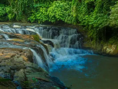 a waterfall in the middle of a river at Digrú Spaa in Pejibaye