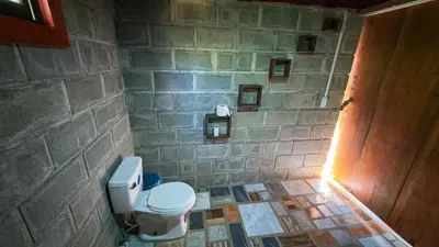 a stone bathroom with a toilet and a stone wall at Digrú Spaa in Pejibaye