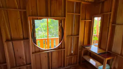 a mirror in a wooden room with a window at Digrú Spaa in Pejibaye