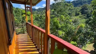 a wooden balcony with a view of the mountains at Digrú Spaa in Pejibaye