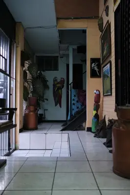 a hallway of a building with paintings on the wall at Hostal del Este Santa Fe in San José