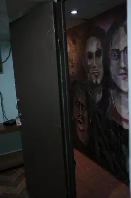 a bathroom with a painting of the killers at Hostal del Este Santa Fe in San José