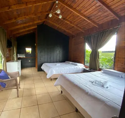 a bedroom with two beds and a window at Grandpas Hotel & Restaurante in Cartago