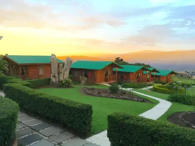 a wooden house with a green roof and a garden at Grandpas Hotel & Restaurante in Cartago