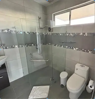 a bathroom with a glass shower and a toilet at casa la luz Orotina in Orotina