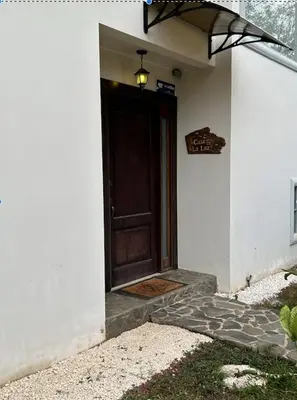 a house with a brown door with a sign on it at casa la luz Orotina in Orotina