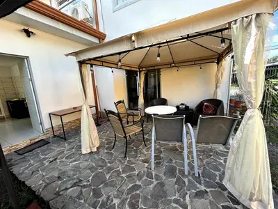 a patio with a table and chairs under an umbrella at casa la luz Orotina in Orotina