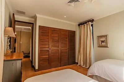 a bedroom with two beds and a closet at Serene 3BR Condo - Bougainvillea - Reserva Conchal Golf Resort in Playa Conchal