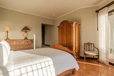 a bedroom with a large bed and a chair at Serene 3BR Condo - Bougainvillea - Reserva Conchal Golf Resort in Playa Conchal