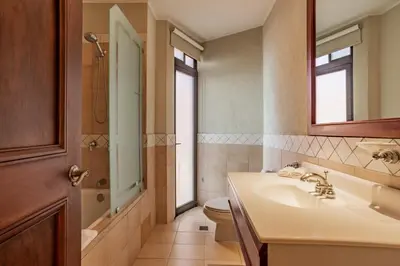 a bathroom with a sink and a toilet and a mirror at Serene 3BR Condo - Bougainvillea - Reserva Conchal Golf Resort in Playa Conchal