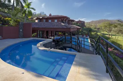 a swimming pool in the backyard of a house at Serene 3BR Condo - Bougainvillea - Reserva Conchal Golf Resort in Playa Conchal