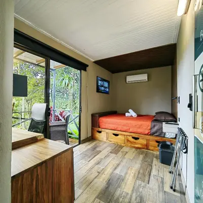 a bedroom with a bed and a sliding glass door at Contenedores Boutique Hotel in Platanal