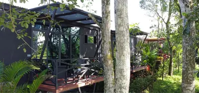 a tree house with a deck in the woods at Contenedores Boutique Hotel in Platanal