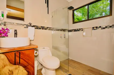 a bathroom with a toilet and a shower and a window at Contenedores Boutique Hotel in Platanal
