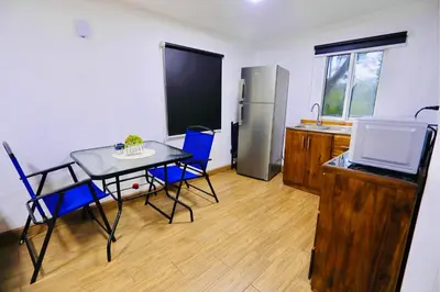 a kitchen with a table and chairs and a refrigerator at Contenedores Boutique Hotel in Platanal