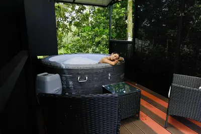 a man laying in a bath tub on a porch at Contenedores Boutique Hotel in Platanal