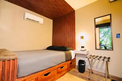 a bedroom with a bed and a mirror at Contenedores Boutique Hotel in Platanal