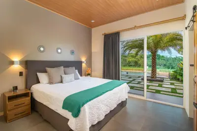 a bedroom with a large bed and a large window at Mayoli Hill Deluxe Farmhouse in Fortuna