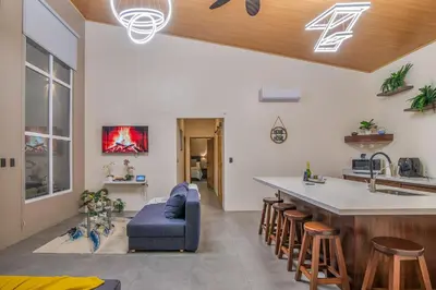 a kitchen and living room with a blue couch and a counter at Mayoli Hill Deluxe Farmhouse in Fortuna