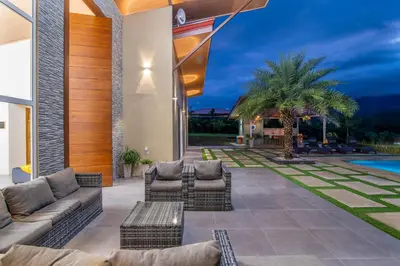 an outdoor patio with couches and a pool at Mayoli Hill Deluxe Farmhouse in Fortuna
