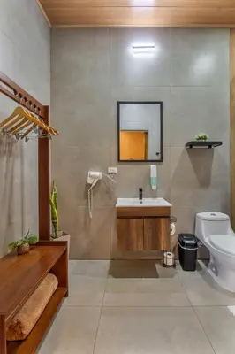 a bathroom with a sink and a toilet and a mirror at Mayoli Hill Deluxe Farmhouse in Fortuna