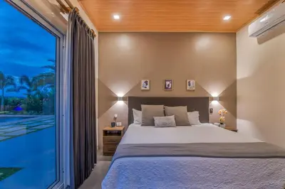 a bedroom with a large bed and a large window at Mayoli Hill Deluxe Farmhouse in Fortuna