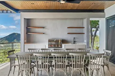 a kitchen with a table and chairs on a balcony at Luxurious Ultramodern Property with Private Suites, Infinity Pool, and Sweeping Ocean and Mountain Views in Potrero