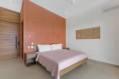 a bedroom with a large bed with a wooden headboard at Luxurious Ultramodern Property with Private Suites, Infinity Pool, and Sweeping Ocean and Mountain Views in Potrero