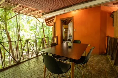 a dining room with a table and chairs on a balcony at B&B Ranchos Itaúna in Santa Teresa Beach